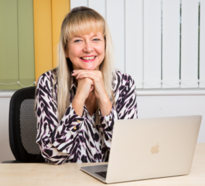 Rachel from Rachel Moore Social Media sat at a desk with laptop